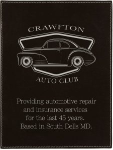 Vintage car emblem on black leatherette plaque for auto club signage.